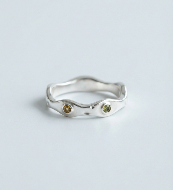 Wavy fine silver ring set with two small green stones